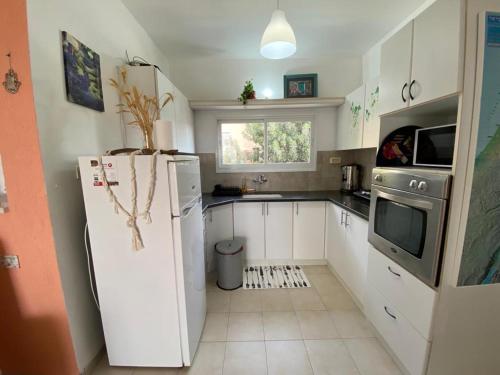 a kitchen with white cabinets and a refrigerator at Villa Sarah in Galilee - All Nations Inn in Poriyya Illit