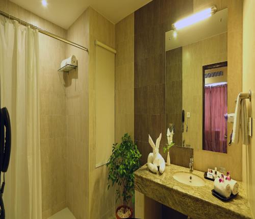 a bathroom with a sink and a shower and a mirror at Renest Tirupati in Tirupati