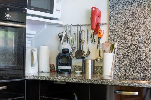 a kitchen counter with utensils on a wall at Jewel Duplex in Fieschertal