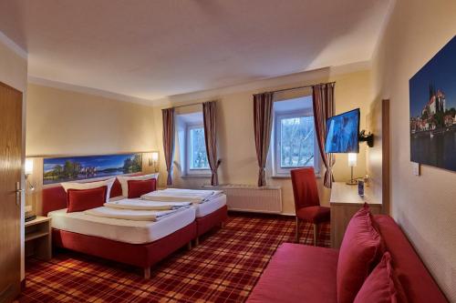 a hotel room with two beds and a couch at Hotel Elbparadies in Pirna