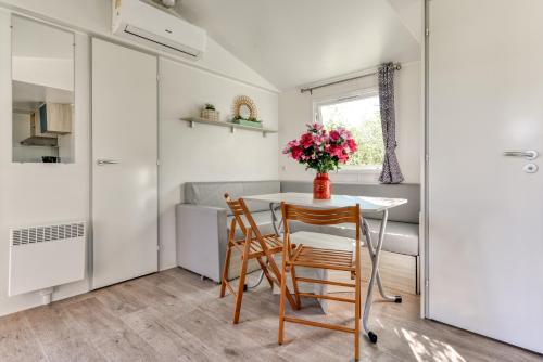 a small kitchen with a table and two chairs at Camping maeva Club Argelès Vacances in Argelès-sur-Mer