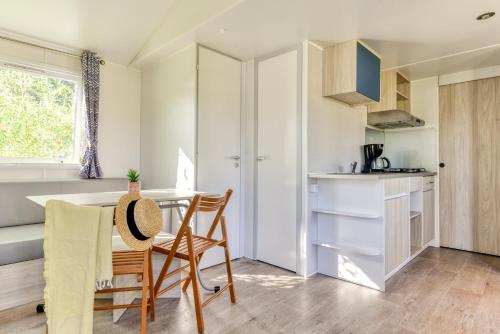 a kitchen with a table and chairs in a room at Camping maeva Club Argelès Vacances in Argelès-sur-Mer