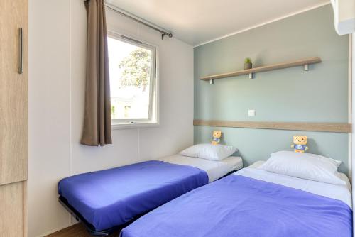 Una cama o camas en una habitación de Camping maeva Club Argelès Vacances