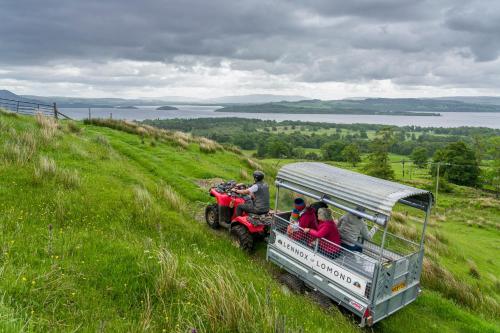 a group of people riding on a atv on a hill at Bonnie Barns - Adults Only Luxury Lodges with hot tubs in Luss