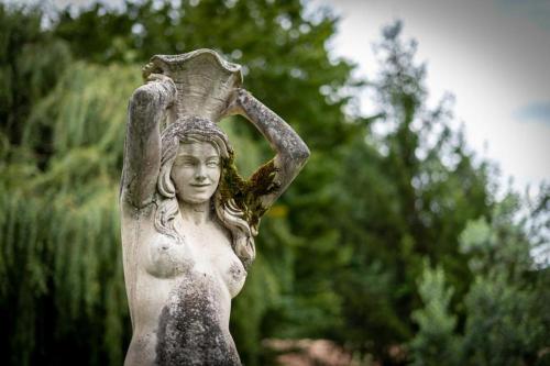 a statue of a woman holding avisor on her head at Un Logis en Angoumois in Rancogne