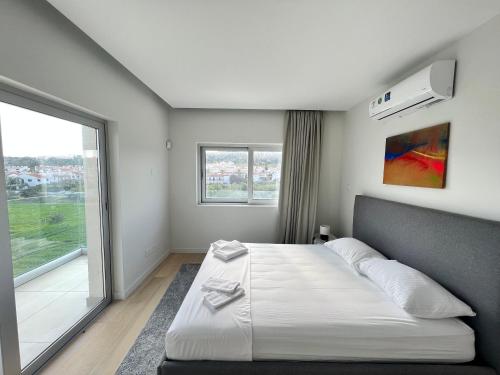 a bedroom with a large bed and a large window at Emerald Suites in Protaras