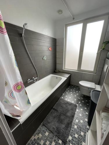 a bathroom with a bath tub and a toilet at Comfortable Room in Alkmaar