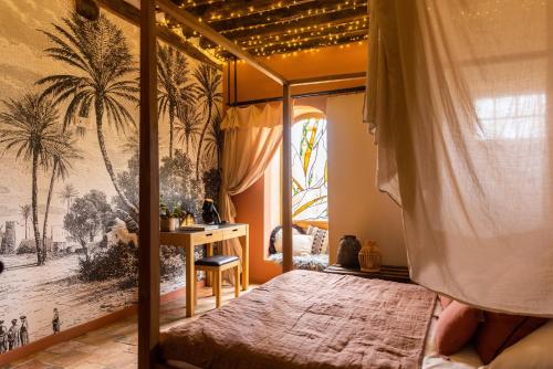 Les Molières的住宿－阿姆諾農場住宿加早餐旅館，一间卧室配有一张天蓬床和一张书桌