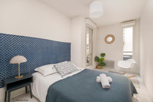 a bedroom with a bed with a blue patterned wall at NOCNOC - Le Cocon Hypercentre in Toulouse