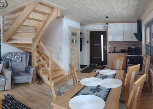 a living room with a dining table and a kitchen at Góralski Domek Tomek in Ciche