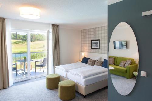 コルスヴァントにあるDorint Resort Baltic Hills Usedomのベッドとバルコニー付きのホテルルーム