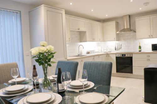 a kitchen with a dining table with wine glasses and flowers at Townhouse, close to harbour with sea views in Padstow