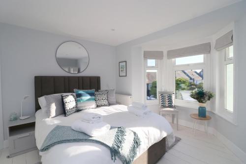 a white bedroom with a large bed with towels on it at Townhouse, close to harbour with sea views in Padstow
