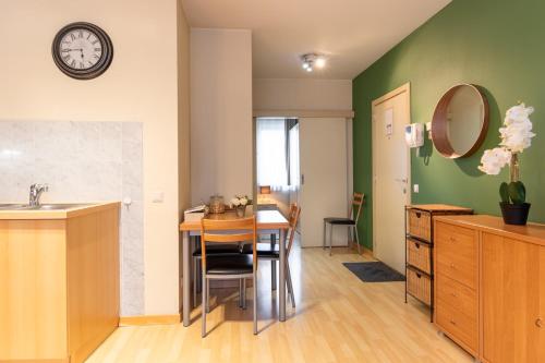 eine Küche und ein Esszimmer mit einem Tisch und einem Spiegel in der Unterkunft Cozy Apartment Brussels Centre in Brüssel