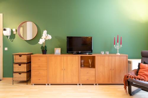 a living room with a television on a wooden cabinet at Cozy Apartment Brussels Centre in Brussels