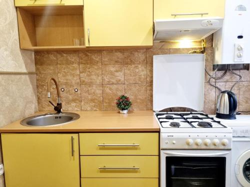 uma pequena cozinha com armários amarelos e um lavatório em 2кімнатні Апартаменти у центрі Дніпра Мечнікова Гагаріна comfort24 em Dnipro