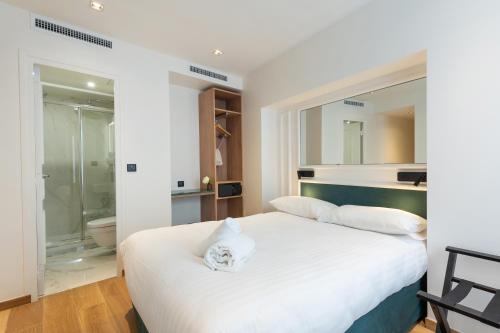 une chambre avec un lit blanc et une salle de bain dans l'établissement HOTEL AU COEUR DE REPUBLIQUE, à Paris