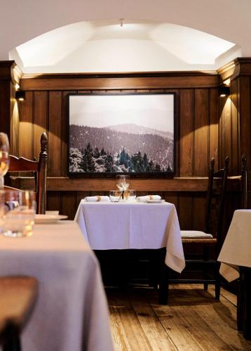 a dining room with two tables and a large screen at Hotel & Restaurant Linde in Münstertal