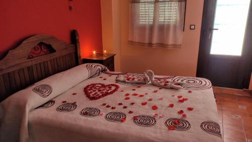 a bedroom with a bed with hearts on it at Alojamientos Rurales Los Molinos in Fuentes de León
