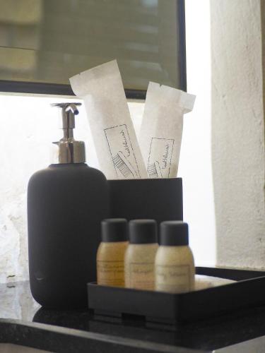 a shelf with a soap dispenser and three bottles at BAAN 125 STAY Phuket in Phuket Town