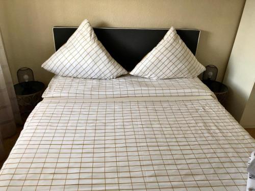 a bed with a black and white checkered blanket at Herz der Weinberge in Gemmrigheim