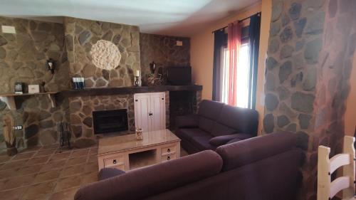 a living room with a couch and a tv at Alojamientos Rurales Los Molinos in Fuentes de León