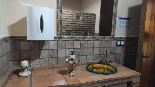 a kitchen counter with a sink and a mirror at Alojamientos Rurales Los Molinos in Fuentes de León