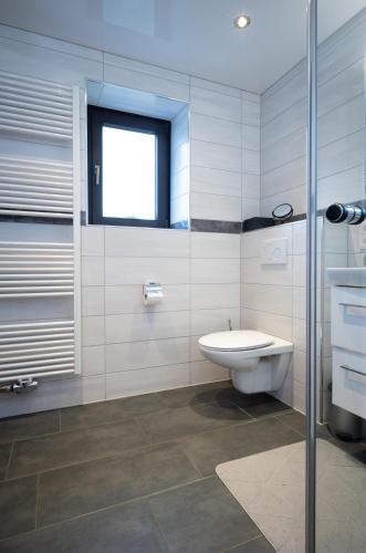 a bathroom with a toilet and a sink and a window at Ferienhaus Schaumbergblick in Losheim