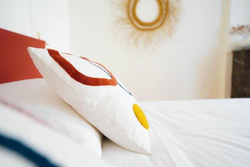 a white pillow sitting on top of a bed at B&B La Maison Galiène in Bordeaux