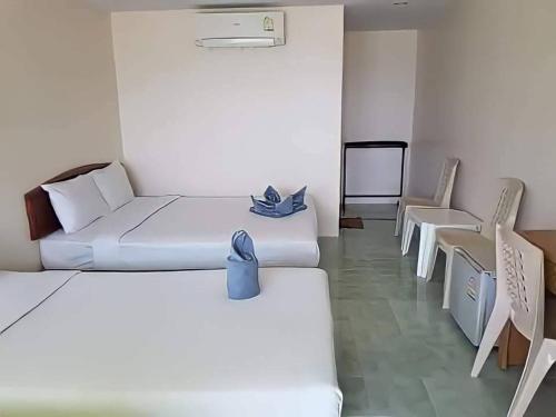 a room with two beds and chairs in it at Dalum Beachhouse in Phi Phi Don