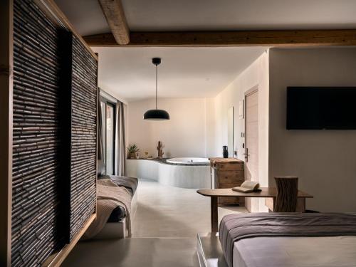 een woonkamer met 2 bedden en een bad bij Gloria Maris Hotel Suites and Villa in Laganas