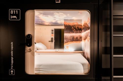 a bed in a hotel room at Capsule Hotel - Alpine Garden Zurich Airport in Kloten
