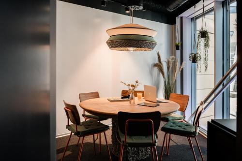a dining room table and chairs in a kitchen at Capsule Hotel - Alpine Garden Zurich Airport in Kloten