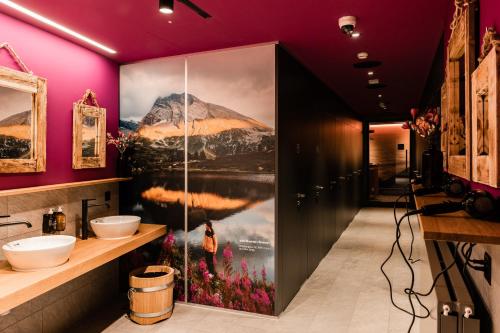 a bathroom with a large painting of a mountain at Capsule Hotel - Alpine Garden Zurich Airport in Kloten