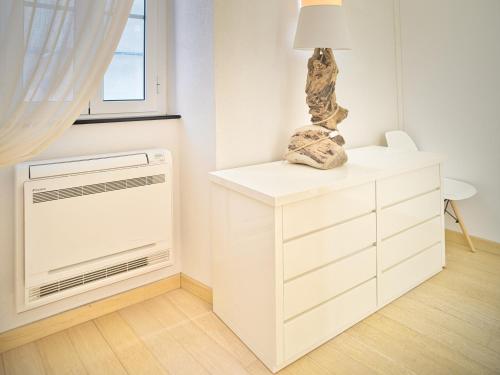 a white room with a chest of drawers and a window at Medusa Apartment - Dépendance in Finale Ligure