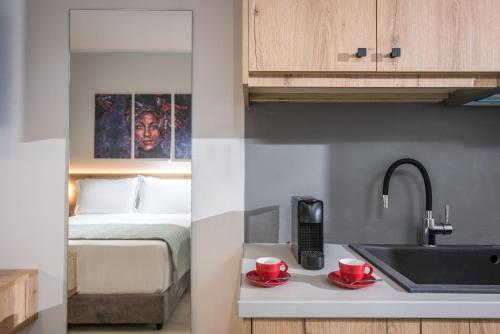 a kitchen with a sink and two red cups on a counter at Nuovo Crete By Sea in Amoudara Herakliou