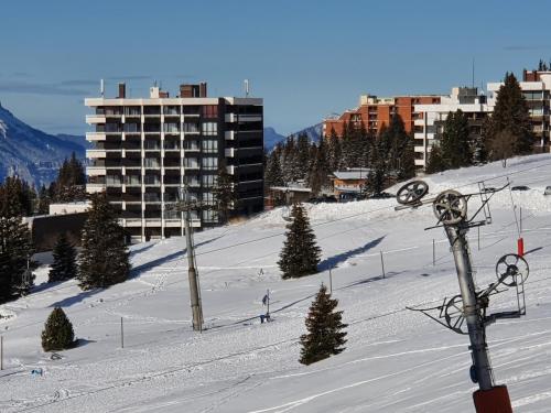 a ski slope in a city with a building at Chamrousse 1750 Roche Béranger 50m2 4-6pers Vue panoramique in Chamrousse
