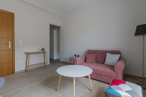 a living room with a pink couch and a table at 105 Adrianou Plaka in Athens