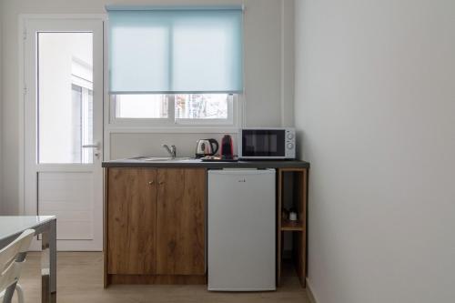 a kitchen with a sink and a microwave at 105 Adrianou Plaka in Athens