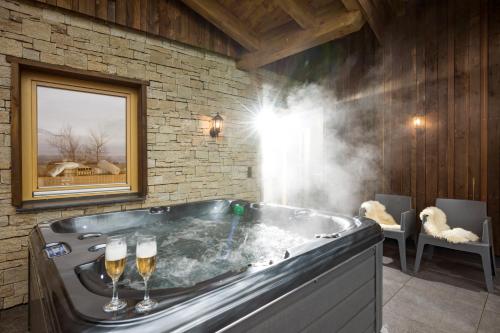 - un bain à remous avec deux verres de champagne dans l'établissement Narzenhof Wellness Chalets, Familien & Luxus Apartments am Bauernhof, à St. Johann in Tirol