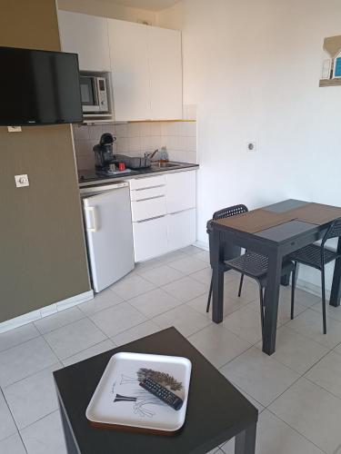 une petite cuisine avec une table et une table sidx sidx sidx dans l'établissement 65 Rue Pierre Rameil Appartement, à Cavalaire-sur-Mer
