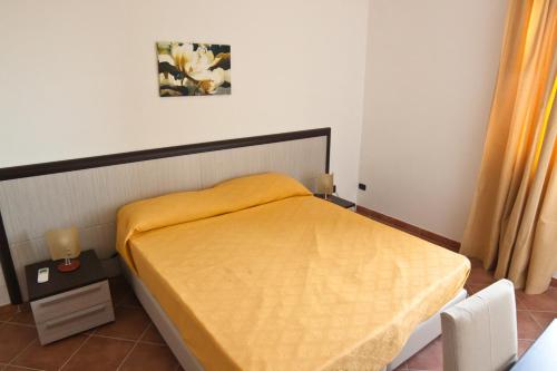 a bedroom with a bed with a yellow blanket at I Tre Pini in Pollica