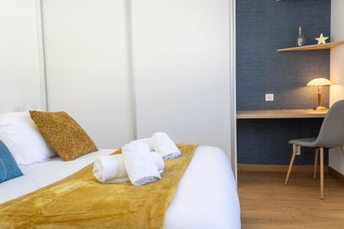 une chambre avec un lit avec des serviettes dessus dans l'établissement LE SAPINOU, Proche lac & vieille ville, Garage, à Annecy