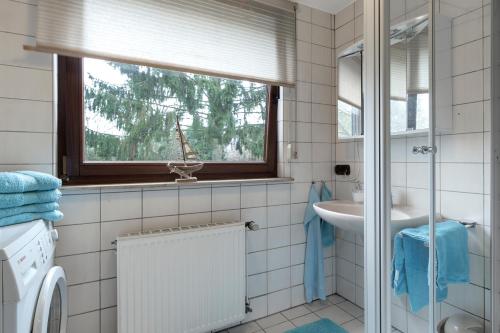 baño con lavabo y ventana en Ferienwohnung-Fuhlsbüttel-Hamburg en Hamburgo