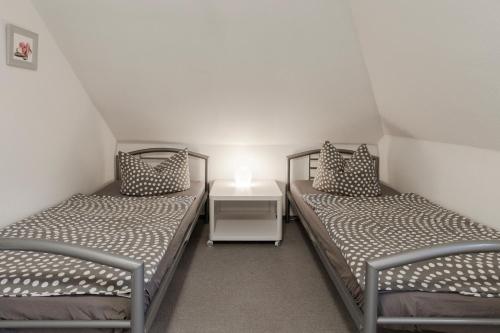 2 Einzelbetten in einem Zimmer mit einem Nachttisch in der Unterkunft Ferienwohnung-Fuhlsbüttel-Hamburg in Hamburg