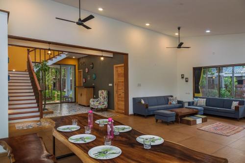 a living room with a table and a couch at SaffronStays Beach Blues, Alibaug in Alibaug