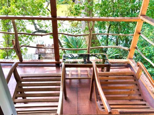 a porch with wooden stairs and a table and chairs at Wilpattu Green Cabin in Achchamulai