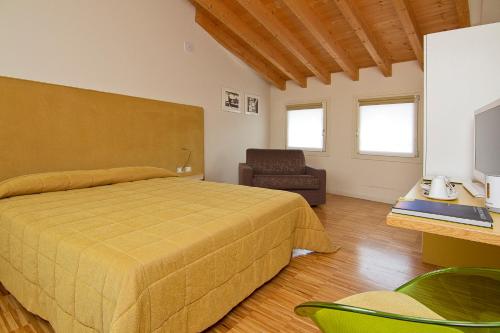 Schlafzimmer mit einem Bett, einem Schreibtisch und einem Stuhl in der Unterkunft Stile Libero in Orio al Serio