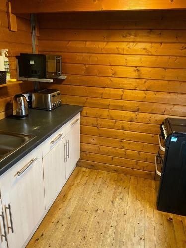 a kitchen with wooden walls and a counter top at Heart of Glencoe Holidays in Glencoe