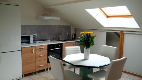 une cuisine avec une table avec un vase de fleurs dessus dans l'établissement Au calme à Avignon, à Avignon